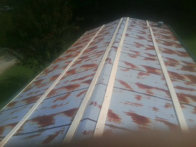 Rusted metal roof panels with new wood purlins before replacement — Storm Damage Roof Repair in Sasser by Roofing Brothers