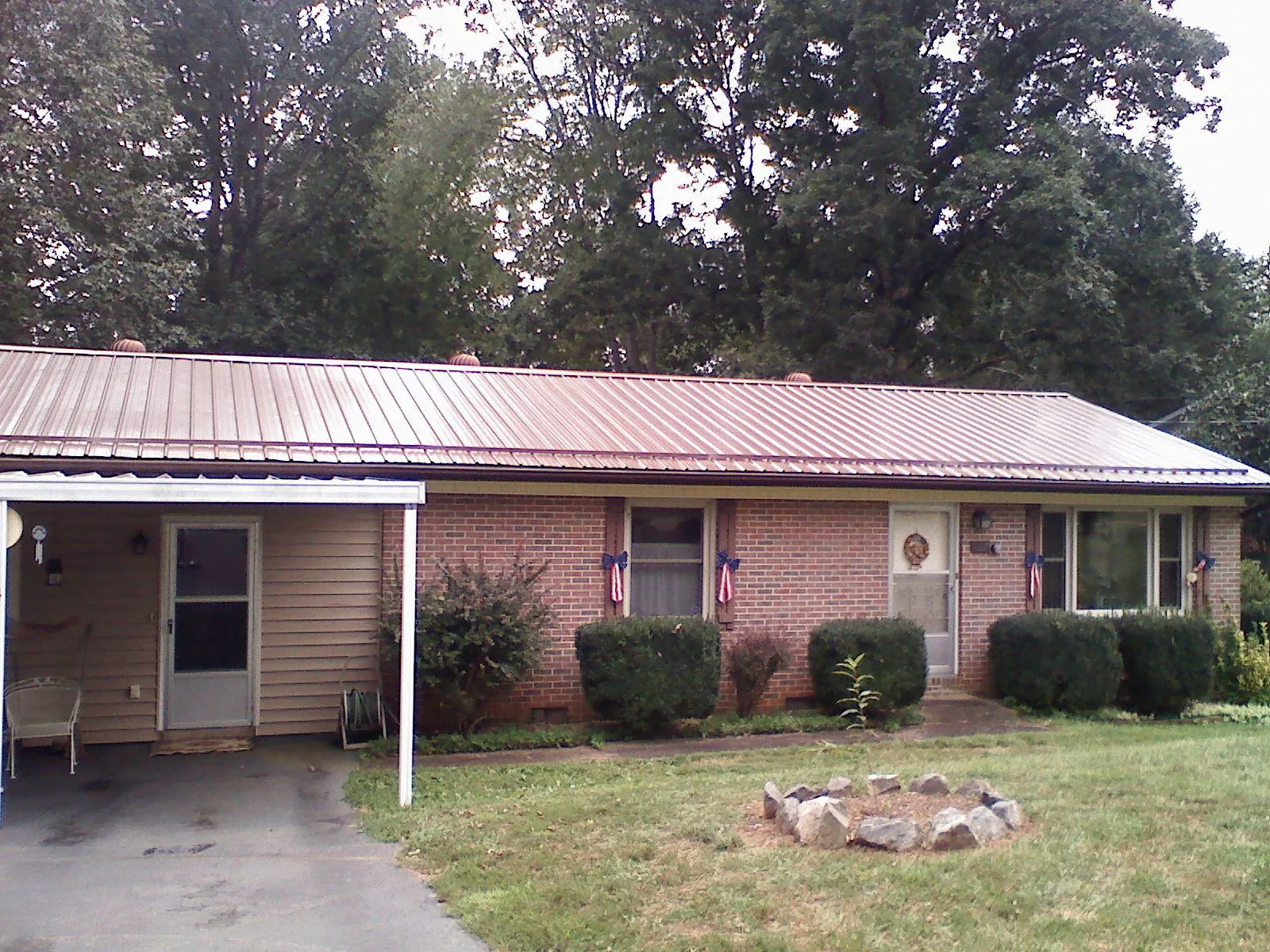 Bronze metal roof and carport on a brick ranch home — Roof Repair work by our crew in Sasser